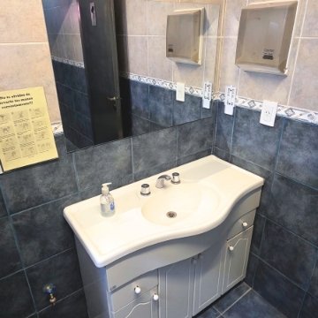 Baño completo y adaptado para movilidad reducida en la residencia geriátrica Casa Trapiche, con ducha a ras de suelo y barras de apoyo.